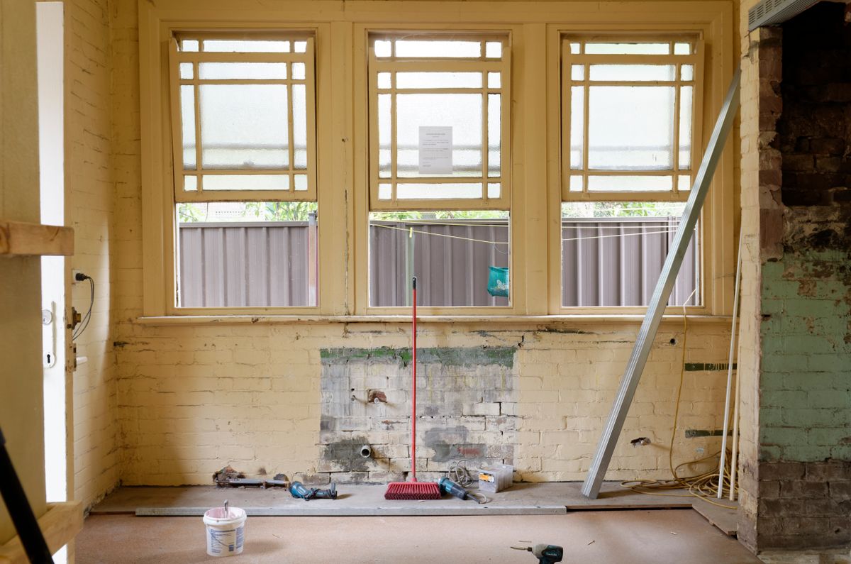 Unfinished room with exposed brickwork and renovation tools